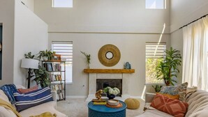 A living room with a fireplace, a bookshelf, and a coffee table.