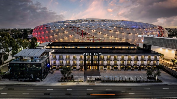 Un hotel moderno con un edificio de forma abovedada destacado en el fondo, que dice "ANTHEM".