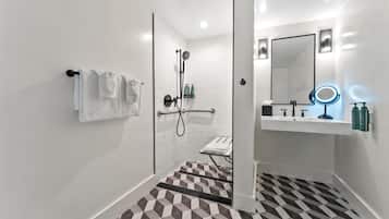 A modern bathroom with a shower, a sink with a mirror, and a towel rack.