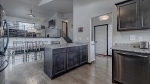 A modern kitchen with dark cabinets, a granite countertop, and stainless steel appliances. - Convenient Location Family-Friendly Locally Owned (Rapid City)