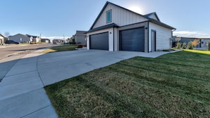 A modern two-story house with a garage, a driveway, and a well-maintained lawn. - Convenient Location Family-Friendly Locally Owned (Rapid City)