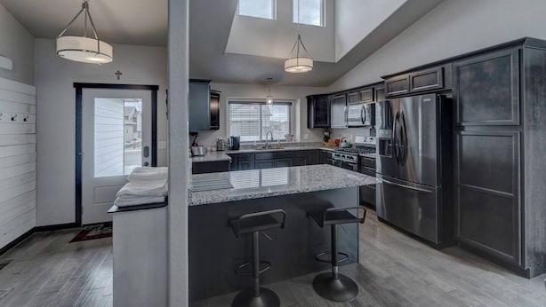 A modern kitchen with a central island, stainless steel appliances, and pendant lighting. - Convenient Location Family-Friendly Locally Owned (Rapid City)