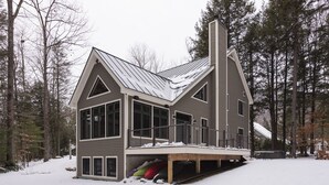 Et moderne hus med to etager, stor garage og overdækket veranda.