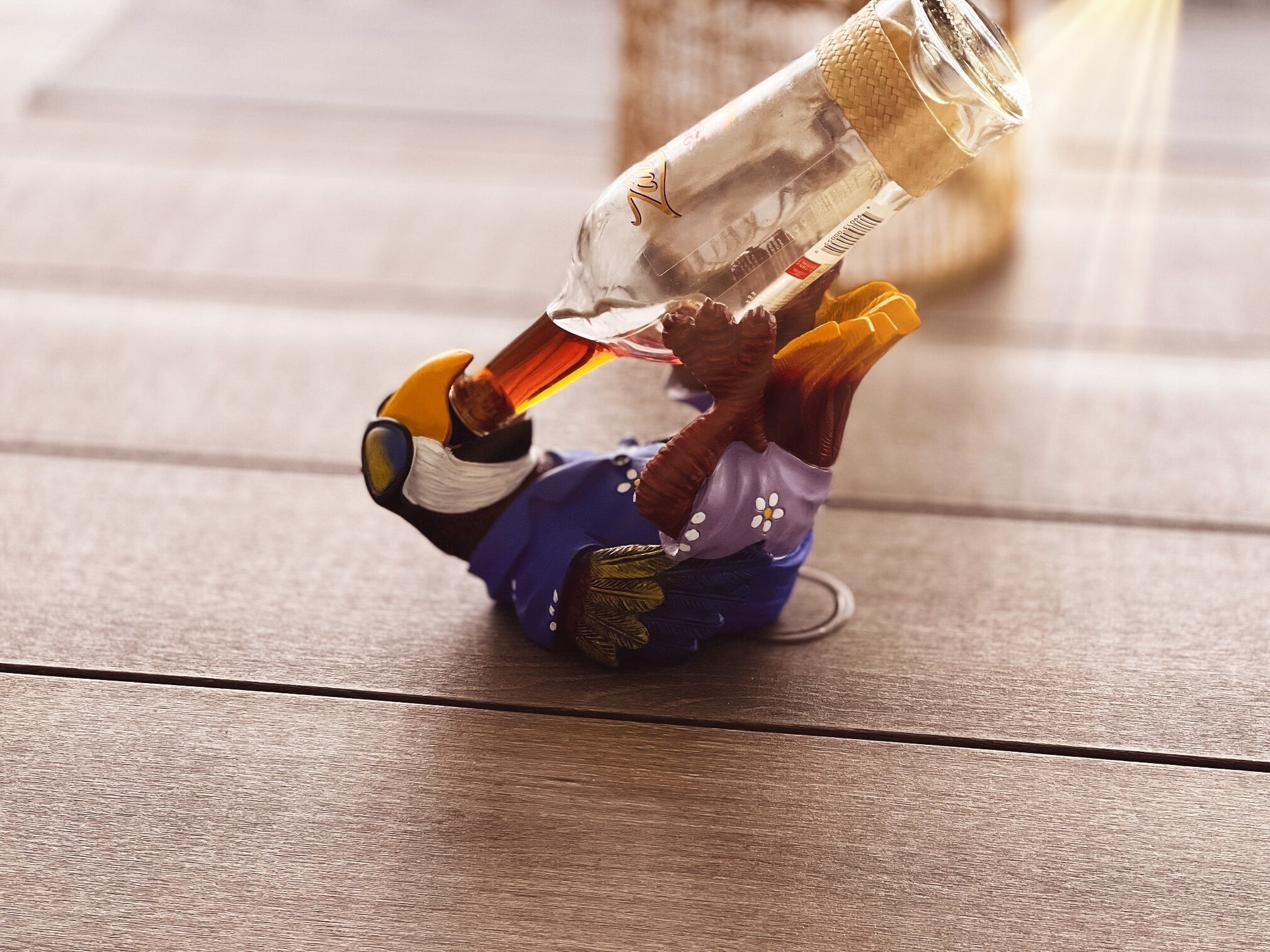 Una figurita de una persona acostada en el suelo con una botella de alcohol.