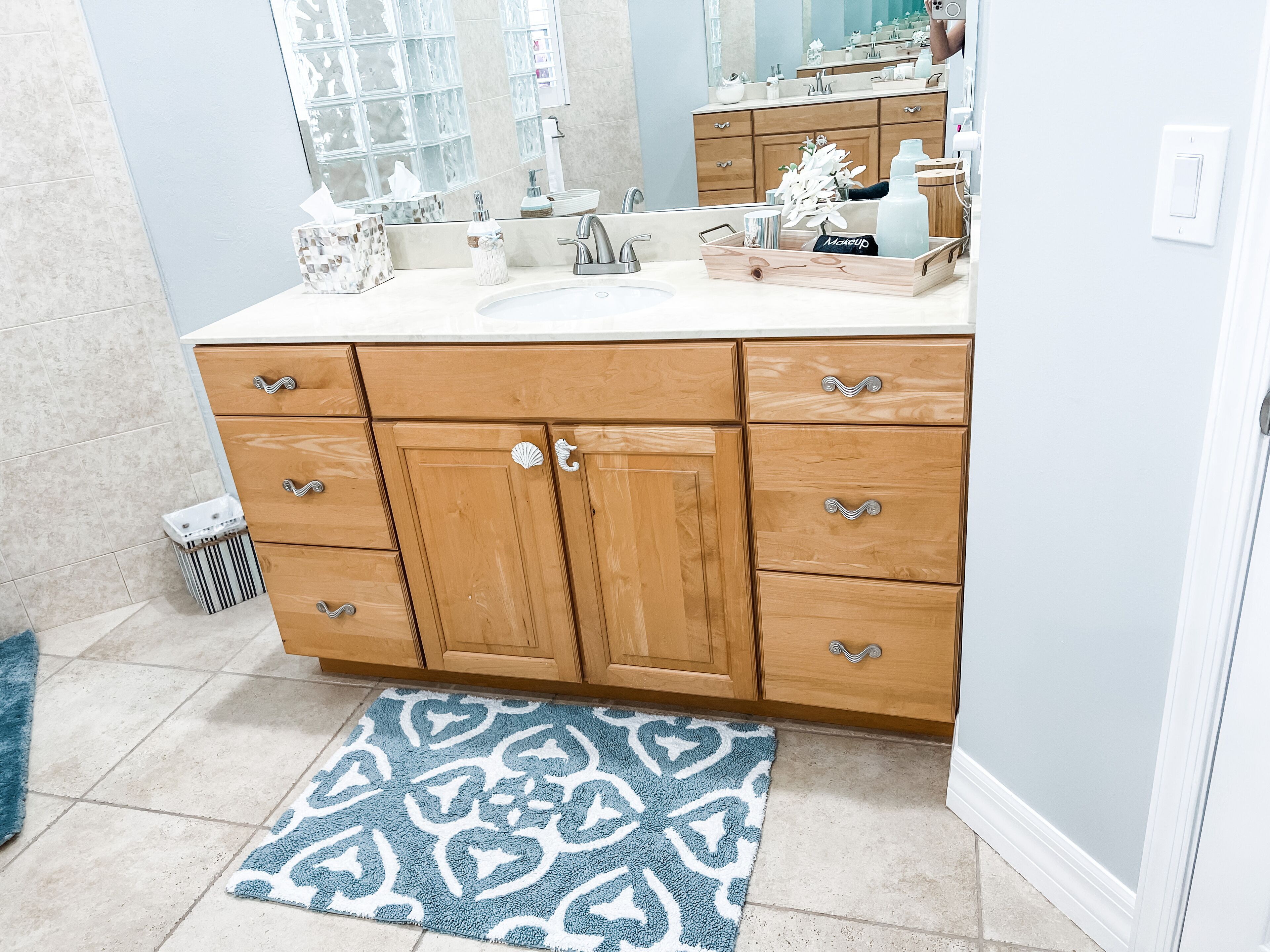 A bathroom with wooden cabinets, a sink, and a mirror.