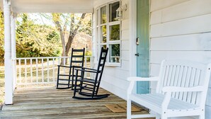 A wooden porch with two rocking chairs and a white bench. - Sea Salt Cottage: Your Tranquil Getaway 3 min to beach (Cape Charles)