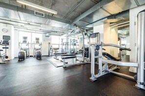 A gym with various exercise equipment, a bench, and a treadmill. - Trendy City Condo, in heart of Midtown Miami (Miami)