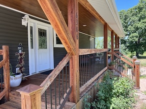Step up to the entrance of this charming home, where a potted plant and bird feeder add a touch of warmth.