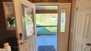 A wooden-floored entrance with a glass door leading to a deck.