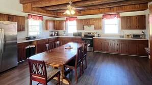 A spacious kitchen with wooden beams, a large island, and modern appliances. - The River House: stone section built in 1790, borders the scenic Juniata  River! (Mifflintown)