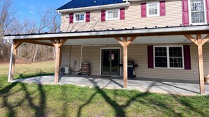A two-story house with a covered porch, a garage, and a large window. - The River House: stone section built in 1790, borders the scenic Juniata  River! (Mifflintown)