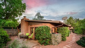 A brick house with a patio, green chairs, and a satellite dish. - Sedona Serene Retreat, Amazing Views & Hot Tub! Walk to Hiking Trails!  (Sedona)