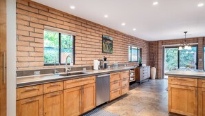 A modern kitchen with wooden cabinets, stainless steel appliances, and large windows. - Sedona Serene Retreat, Amazing Views & Hot Tub! Walk to Hiking Trails!  (Sedona)