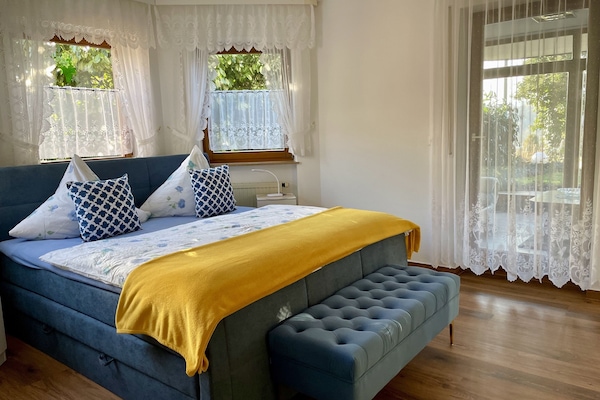 Ferienwohnung Sonneneck- bequemes Boxspringbett mit gepolsterten Sitzbänkchen zum Anziehen.