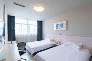 A hotel room with two beds, a desk, a chair, a TV, and a window with curtains. - Jinjiang (Gaoyou Haichao East Road) (Gaoyou)