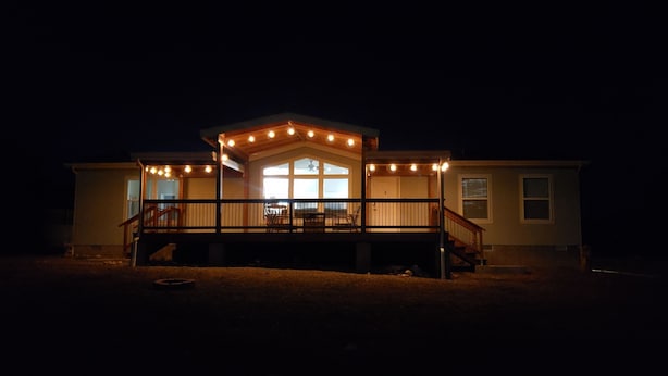 Een huis met een overdekte veranda en een trap naar een terras.
