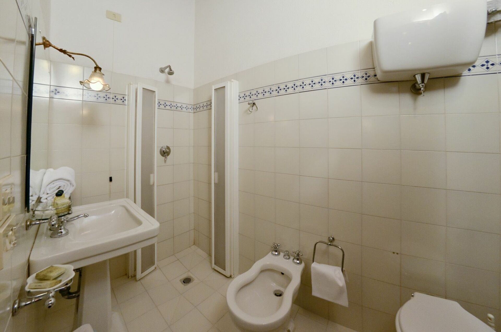 Ein Badezimmer mit Waschbecken, Bidet, Toilette und Duschkabine.