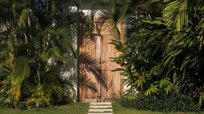 Una puerta de madera rodeada de exuberante follaje tropical.