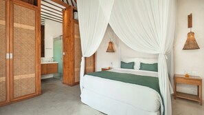 Une chambre à coucher avec un lit, une table de chevet, une armoire en bois, et une salle de bain visible au fond.