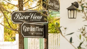 Señal direccional con indicaciones hacia 'River View Cottage' y 'Garden View Cottage'.