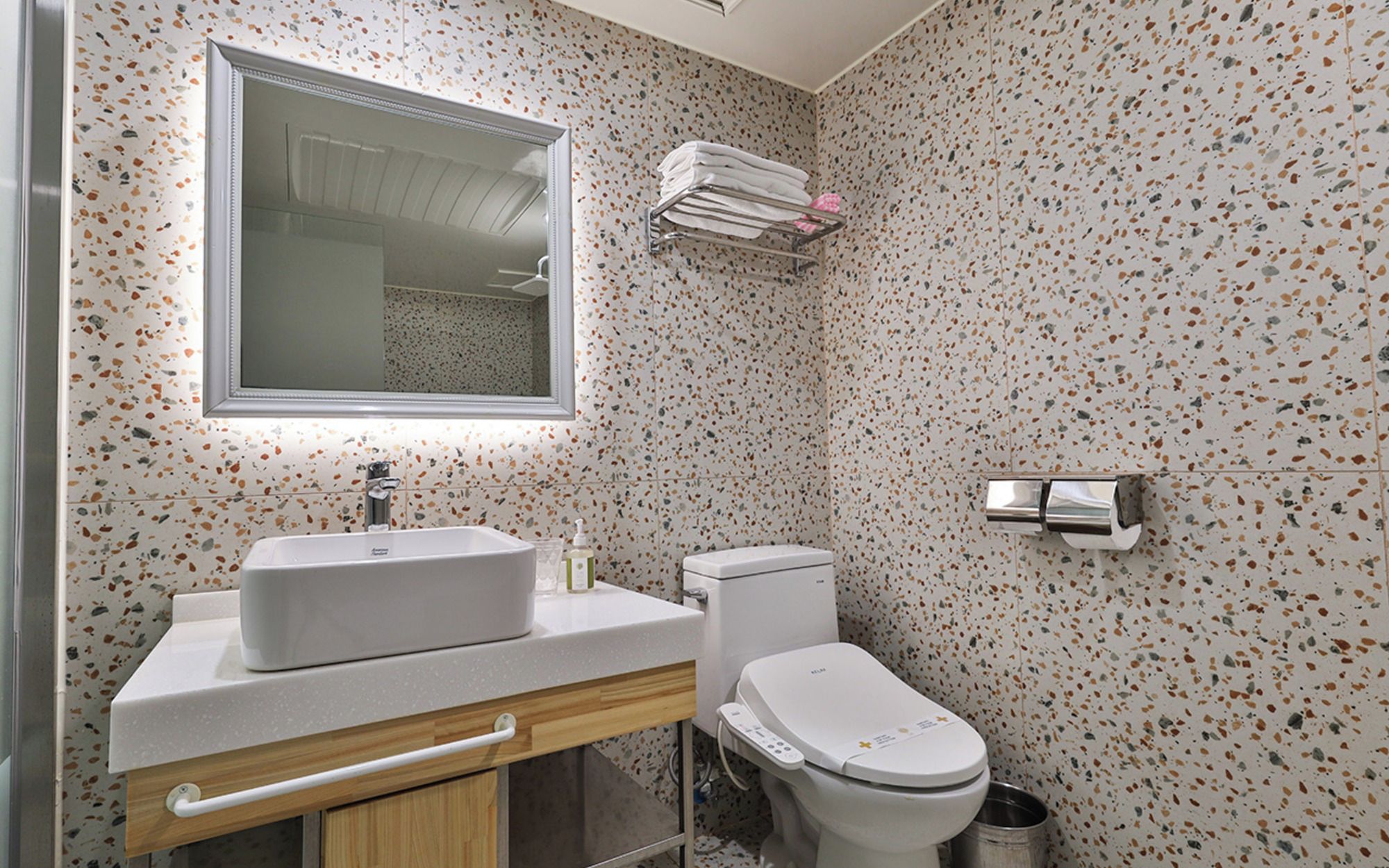 A bathroom with a white sink, a toilet, and a mirror above the sink.