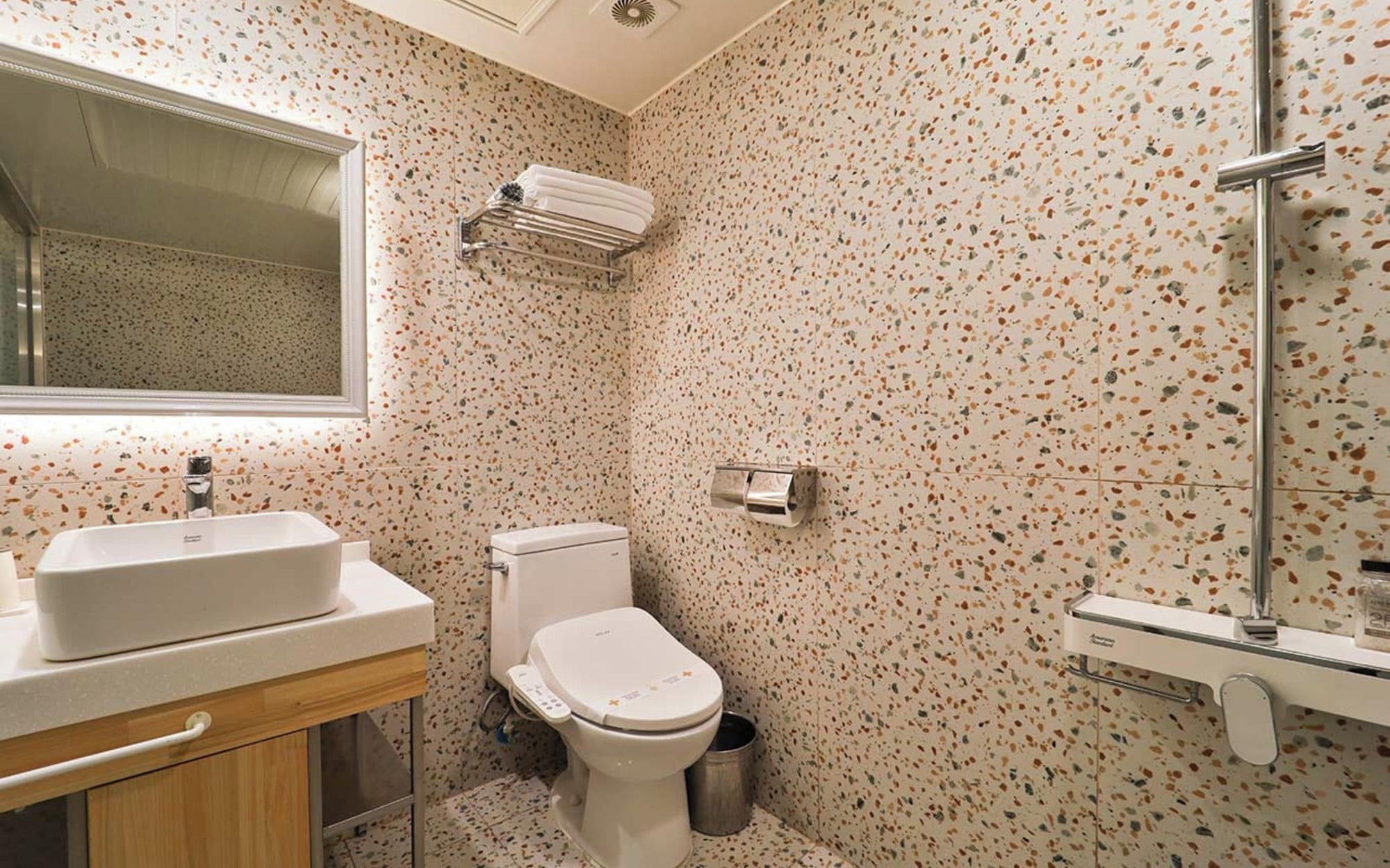 Un baño con lavamanos independiente, inodoro y zona de ducha.
