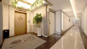 A hotel lobby with a reception desk, a potted plant, and a sign reading "Boutique Hotel". - Hotel February Dongdaegu (Daegu)