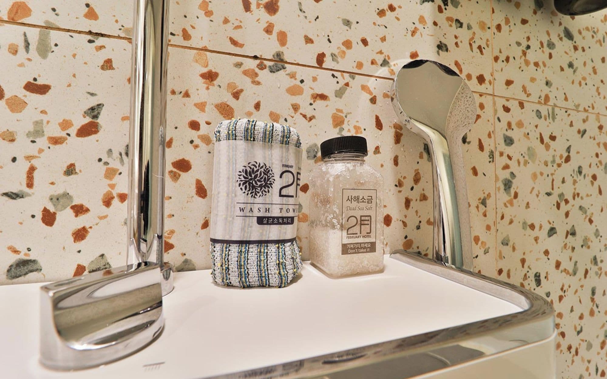 Un baño con encimera blanca, dispensador de toallas y salero.