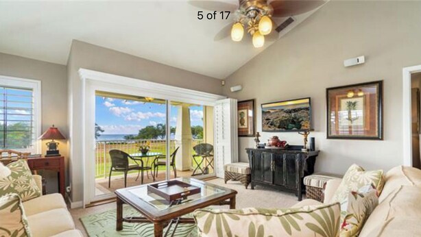 A spacious living room with a sofa, coffee table, and a balcony with a view.