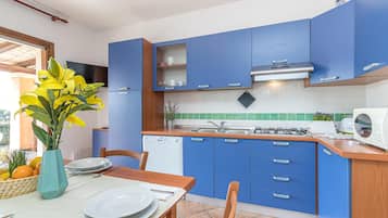 Apartamento família, vários quartos, 2 banheiros (Le Dimore di Nettuno 1 With Pool) | Cozinha privada | Geladeira, micro-ondas, cooktop, lava-louças