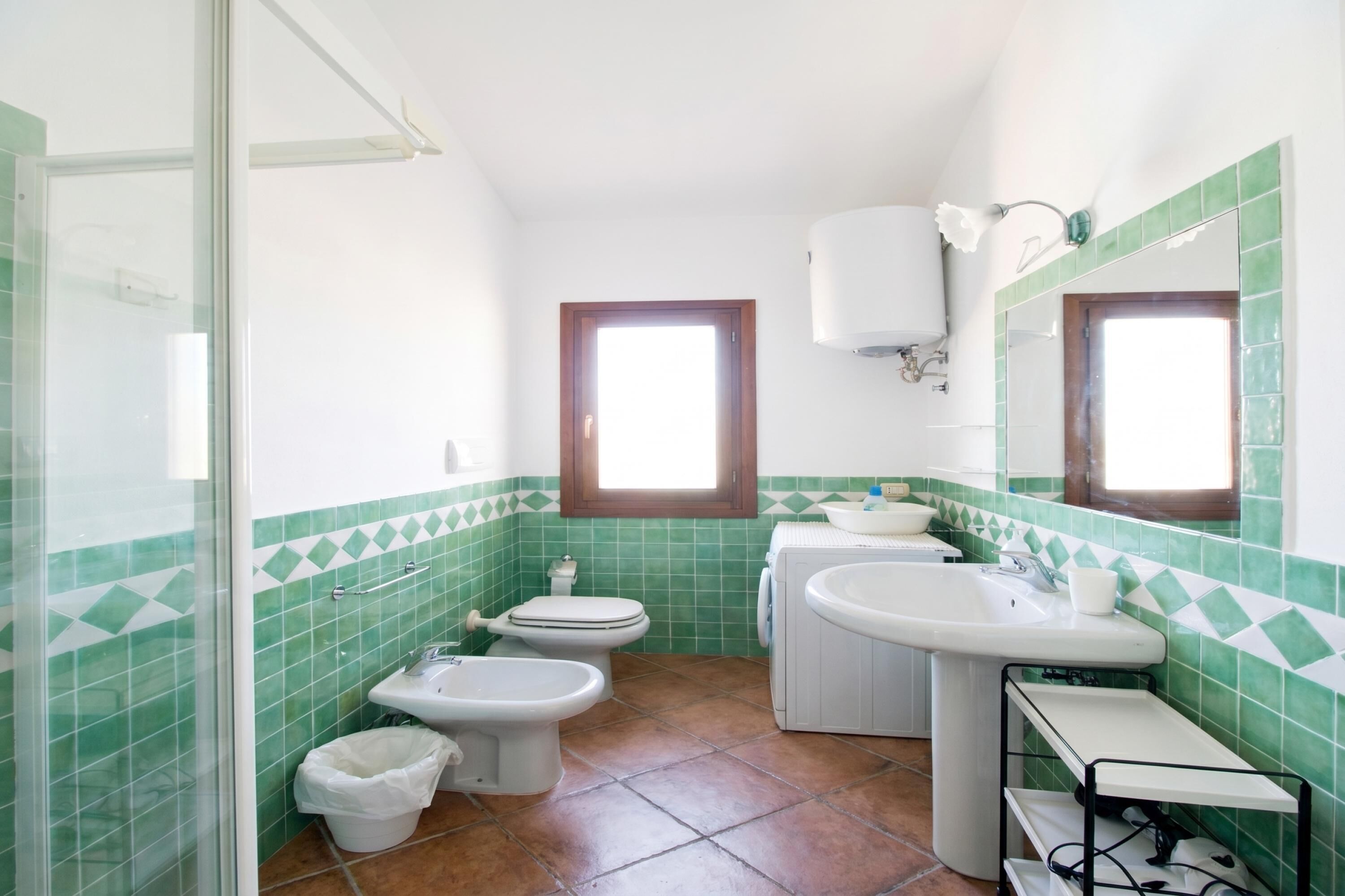 Ein Badezimmer mit Toilette, Bidet, Waschbecken und Spiegel.