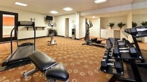Une chambre d’hôtel équipée d’un tapis de course, d’un vélo d’appartement et d’un fauteuil de massage.