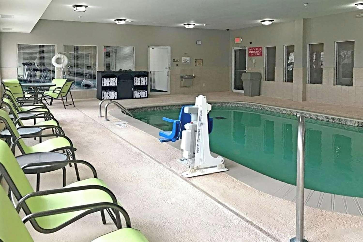A pool area with chairs and a poolside table.