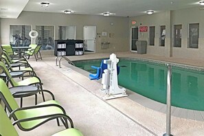 A pool area with chairs and a poolside table. - Comfort Inn & Suites Ofallon - St Louis Area (O'Fallon)