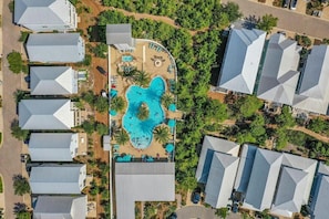 An aerial view of a residential area with multiple houses, a central swimming pool, and surrounding greenery. - 6 Seater Golf Cart! Bikes! Easy Beach Access! Close to Pool!- Best Kept Secret at Highland Parks 30A (Santa Rosa Beach)