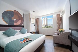 Una habitación de hotel moderna con una cama grande, un escritorio, una silla y un televisor.