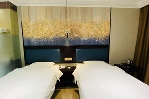 A hotel room with two beds, a nightstand, a telephone, and a decorative wall piece.
