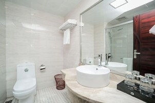 Un baño moderno con inodoro, lavamanos y ducha.