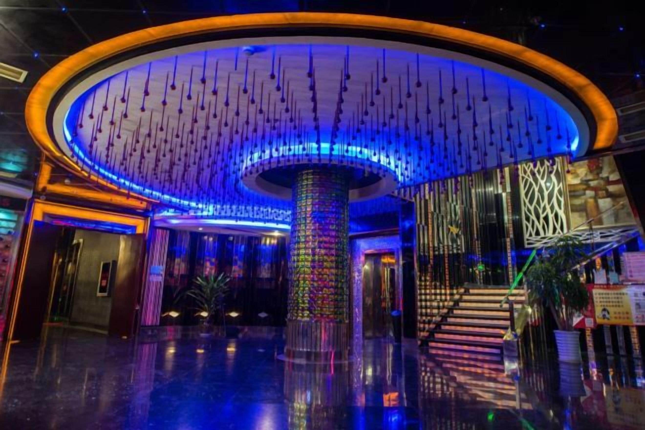 A lobby with a central column, a staircase, and a modern design.