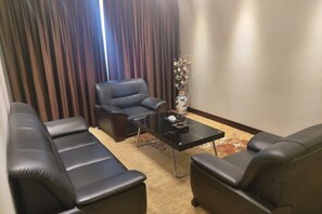 A living room with a sofa, a chair, and a coffee table. - Huayuan Hotel (Zhongjiang)