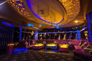 A luxurious interior with ornate ceiling designs, plush seating, and ambient lighting. - Huayuan Hotel (Zhongjiang)