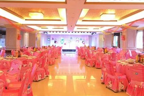 A banquet hall with rows of tables, chairs, and a stage. - Huayuan Hotel (Zhongjiang)