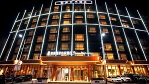 A hotel with a modern facade, multiple floors, and a prominent entrance with a covered area. - Greenman Lv Yijia Hotel (Poyang)