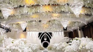 An ornate hallway with chandeliers, floral arrangements, and a reflective floor. - Greenman Lv Yijia Hotel (Poyang)