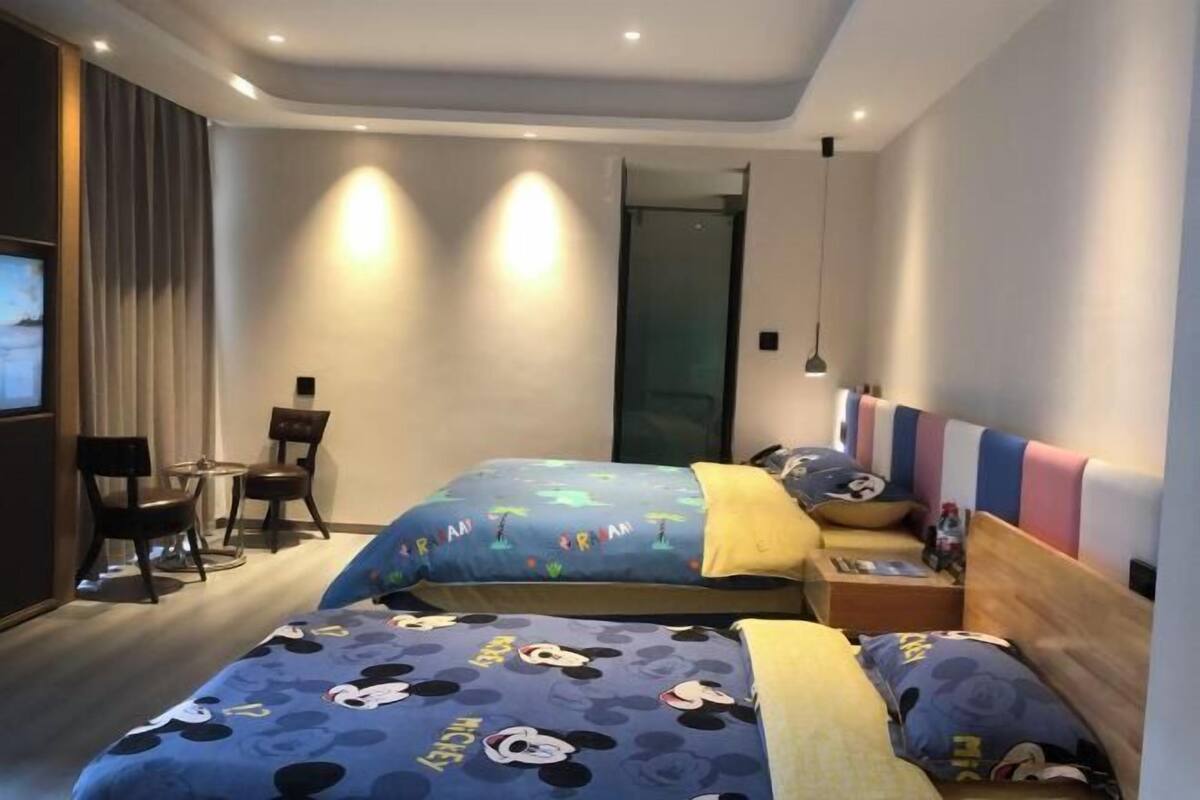 Ein Hotelzimmer mit zwei Betten, einem Schreibtisch und einem Stuhl.