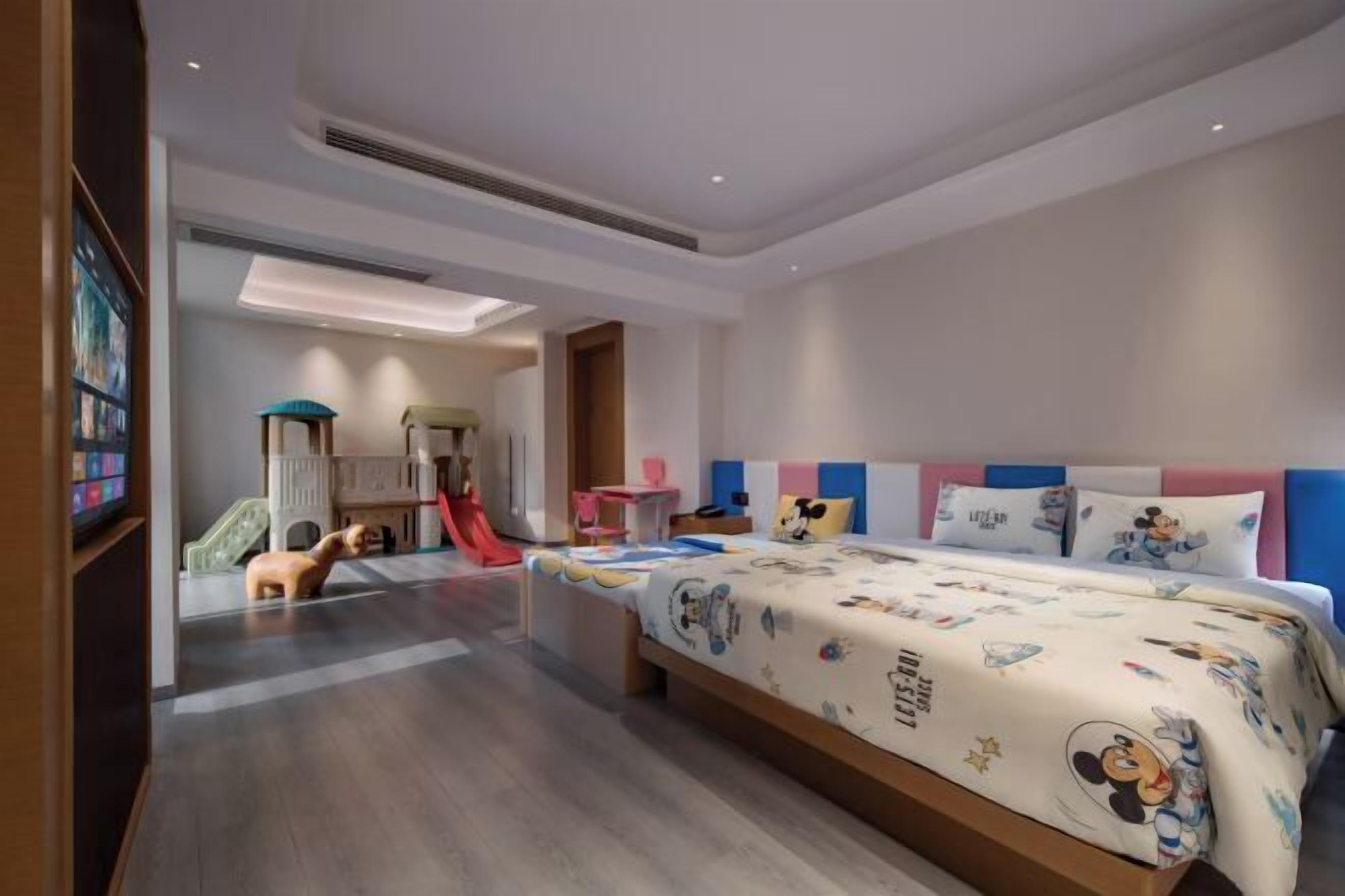 A modern children's room with a bed, play area, and a slide.