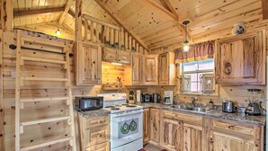 Eine Holz-Küche mit Herd, Mikrowelle und verschiedenen Geräten.