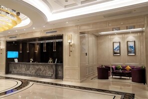 A hotel lobby with a reception desk, seating area, and a large chandelier. - Greentree Eastern Hotel (Jianhu Ouba Liya Life Square) (Jianhu)