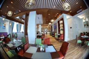Un restaurant doté de plusieurs tables et chaises, d’un plafond en bois et offrant une vue sur la salle à manger.
