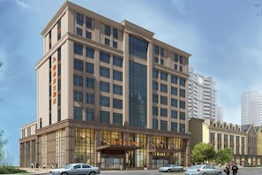 A multi-story hotel with a prominent entrance, large windows, and a modern architectural design.